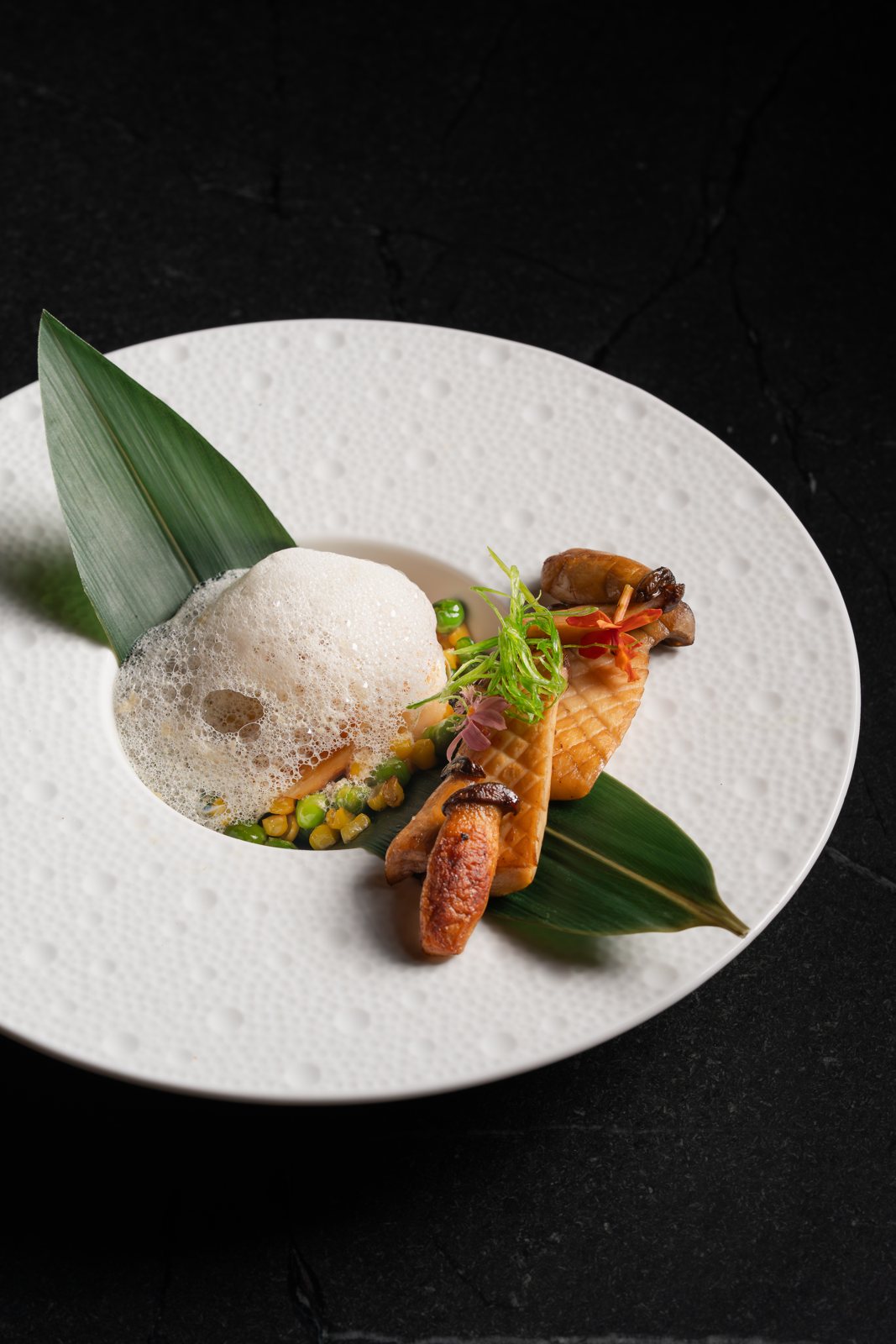 Miso-glazed Black Cod with sweet corn and peas under a light foam at MUI Supper Club